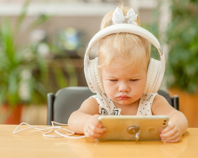 Kleinkind mit Kopfhörer und Smartphone