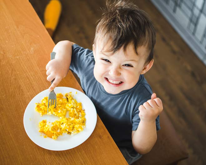 Kind Frühstück Rührei selbstbewusst